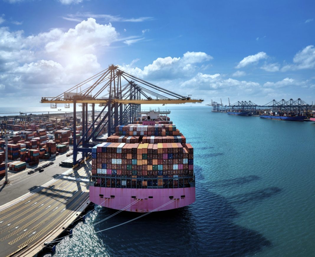 Aerial view of cargo ship and cargo container in harbor.